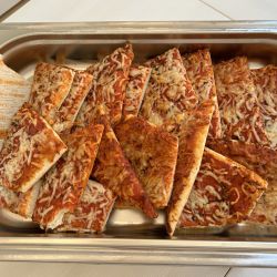 Auf einem Tablett liegen viele dreieckige Pizzastücke mit Käse und Tomatensoße, die ein köstliches Buffet bilden.