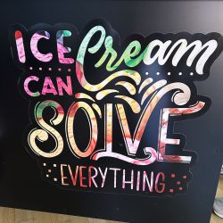 Bunte Schrift auf einer schwarzen Tafel verkündet optimistisch, dass Eiscreme jedes Problem lösen kann.
