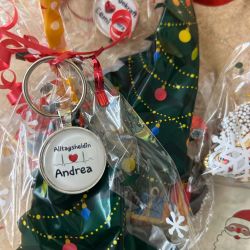 Weihnachtliche Geschenkverpackungen mit personalisierten Schlüsselanhängern liegen dekorativ nebeneinander.