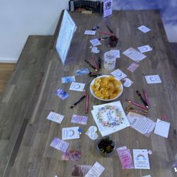 Bunte Karten, Stifte und Snacks sind dekorativ auf einem Holztisch arrangiert und schaffen eine einladende Atmosphäre.