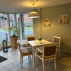 Ein gemütlicher Essbereich mit Tisch und vier Stühlen wird von stimmungsvoller Beleuchtung angenehm erhellt.